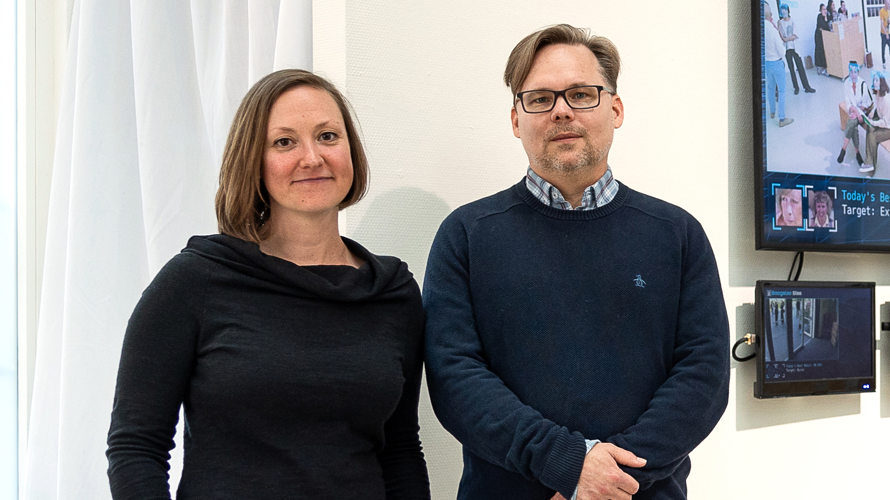 Derek Curry and Jennifer Gradecki standing in front of their installation Boogaloo Bias
